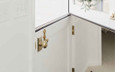 Emtek 8516 Dutch Door Bolt close-up at door split, Polished Brass finish, showing bolt knob and mounting base