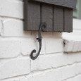 Delaney S Hooks Exterior Shutter Blind Hinge installed on white brick exterior wall below a dark wood shutter, black iron finish