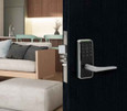 Dormakaba Saffire EVO LZ-L electronic lock installed on a dark door in a hotel room setting, showing latch and lever in context