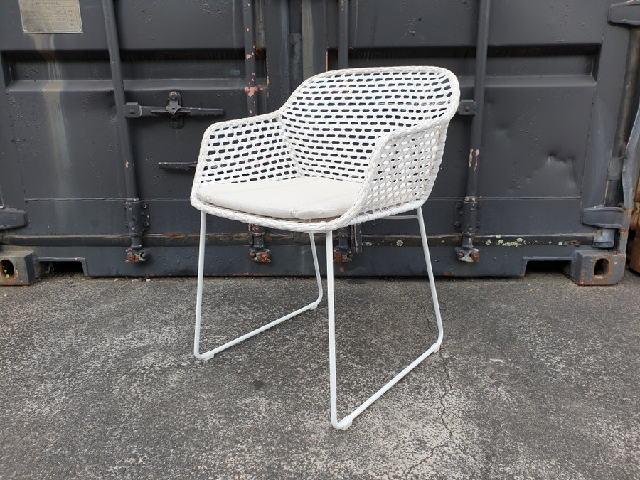 Angle view of IRIS Outdoor Dining Arm Chair with  2 tone chalk white and pale beige interlaced wicker and canvas sand squab