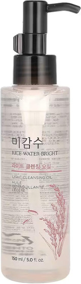 Close-up of the cleansing oil bottle with golden rice water visible inside.