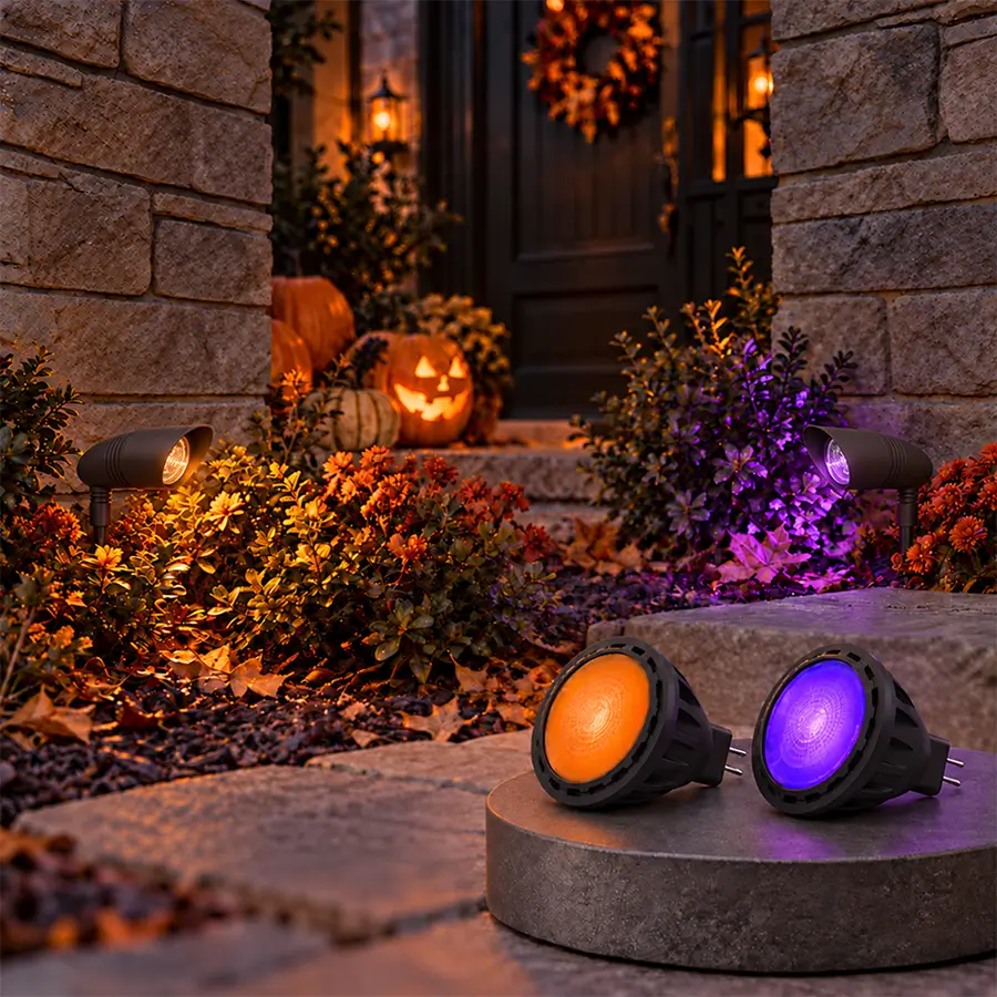 Orange and purple RGBCW MR16 bulbs and spotlights lighting a Halloween porch