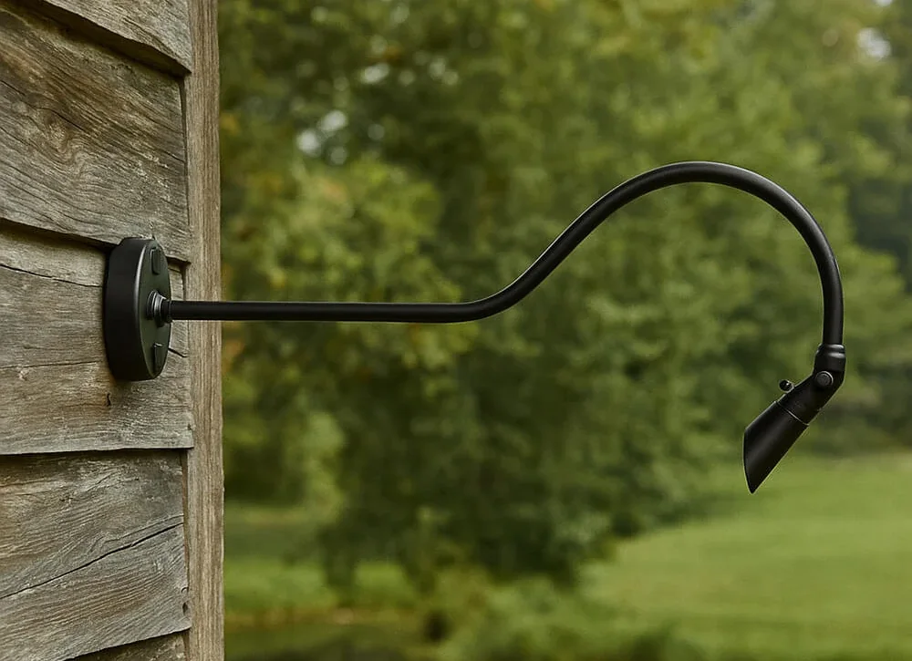 Gooseneck bullet light on a weathered wood wall beside a field