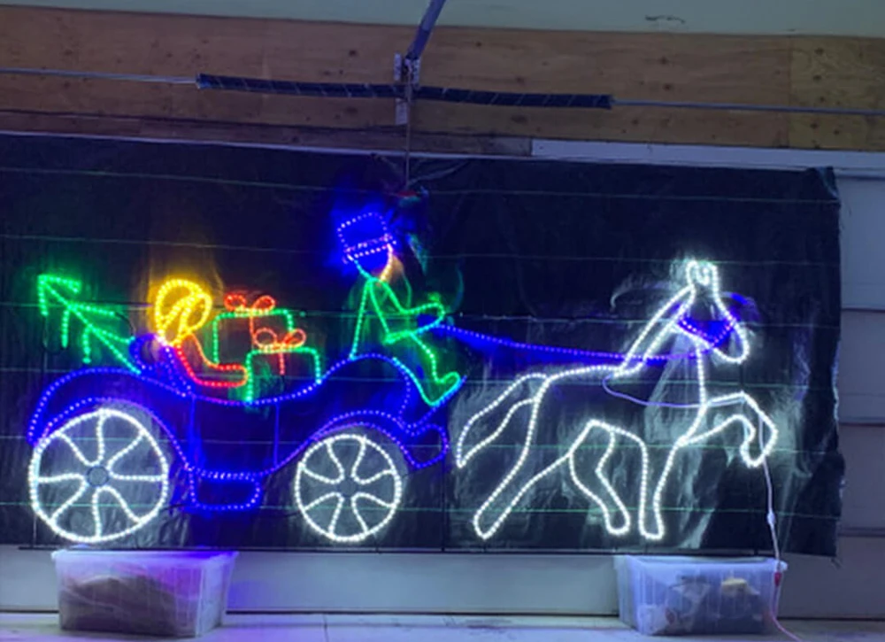 Rope light shaped into a lit horse-and-carriage display