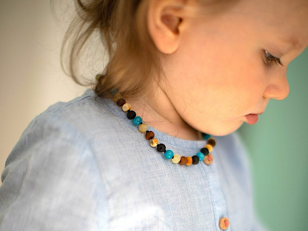 Handmade children’s necklace with raw Baltic amber nuggets and blue agate gemstone details - traditional teething style design