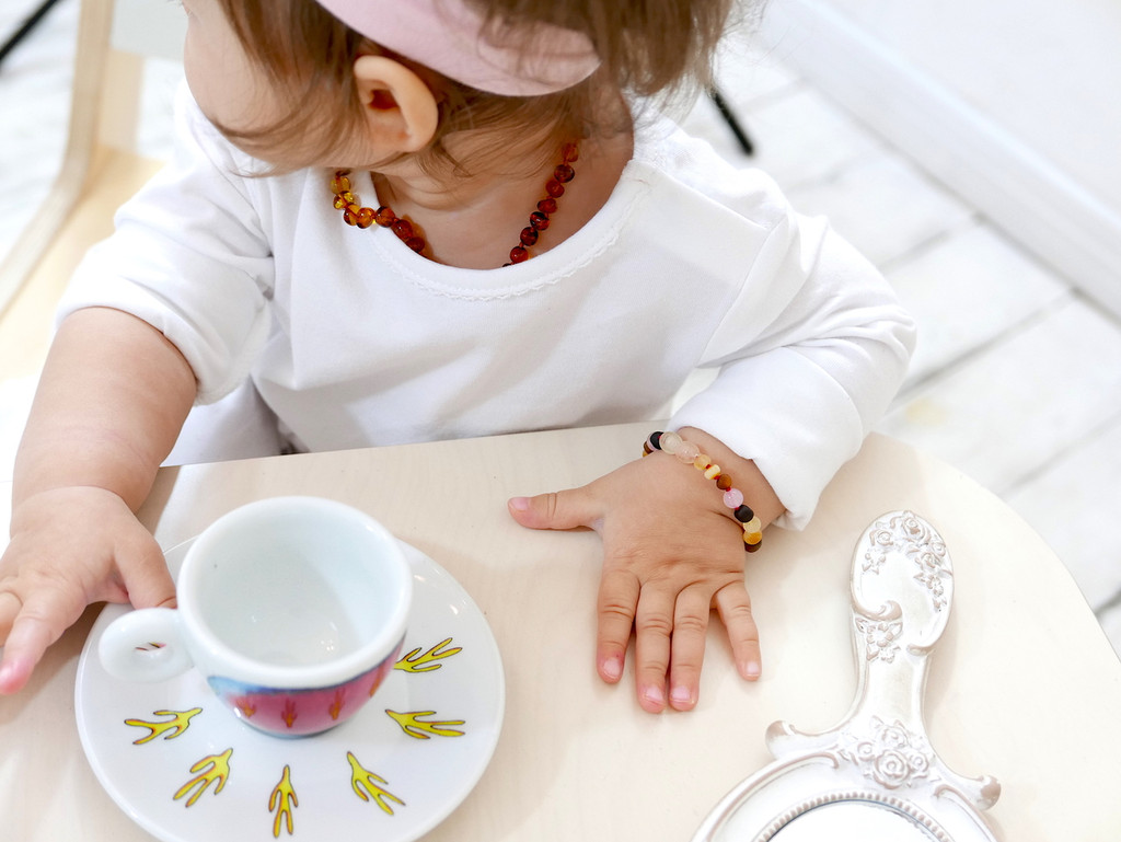 Baltic amber teething bracelet with delicate pink quartz stones and secure clasp