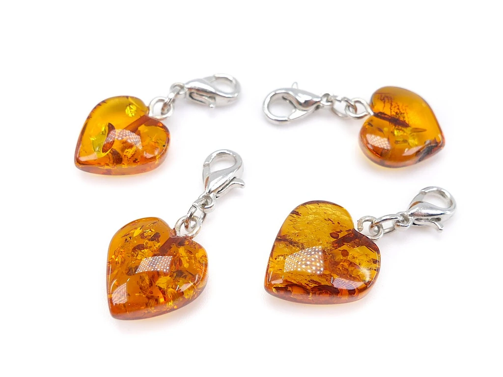 Certified Baltic Amber Heart Jewellery Charm – Genuine Baltic amber pendant featuring a carefully carved heart design, natural amber colour variations and a silver-coloured clasp for easy attachment to kids & adult jewellery