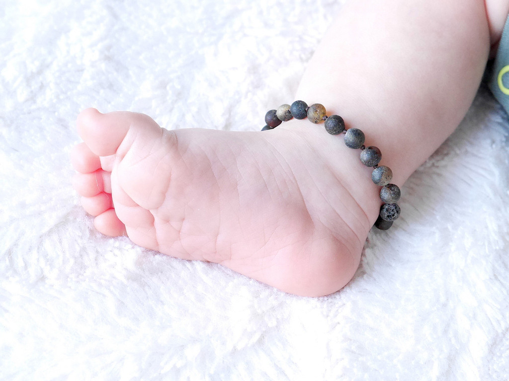 Grey raw amber teething anklet for kids crafted from authentic Baltic amber with smooth rounded beads 