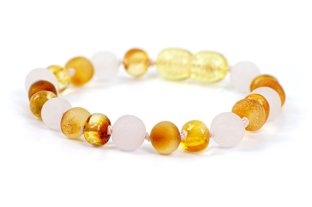 Baby amber teething bracelet featuring matte pink rose quartz and baroque amber beads, ethically made in the Baltic region