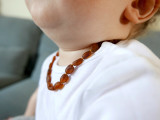Unpolished cognac Baltic amber teething necklace for babies and toddlers featuring olive-shaped knotted beads