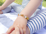 close-up of amber and aquamarine child bracelet showing natural bead texture and secure clasp - traditional teething style design