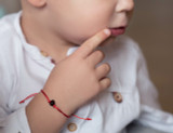 Kids Red String Kabbalah Bracelet with dark cherry polished amber