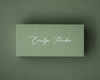 Olive green flat place card with white ink printed name in the same elegant handwritten style.
