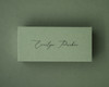 Olive green flat place card with black ink printed name in a modern script font.