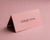 Personalised blush pink folded place card with elegant black ink printing.