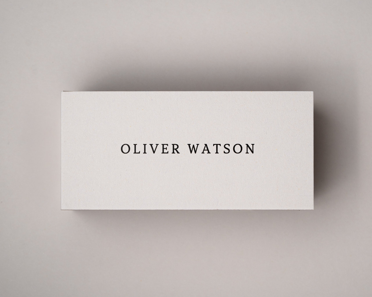Personalised ivory place card printed in black serif font, centred cleanly on 300gsm almond cardstock.