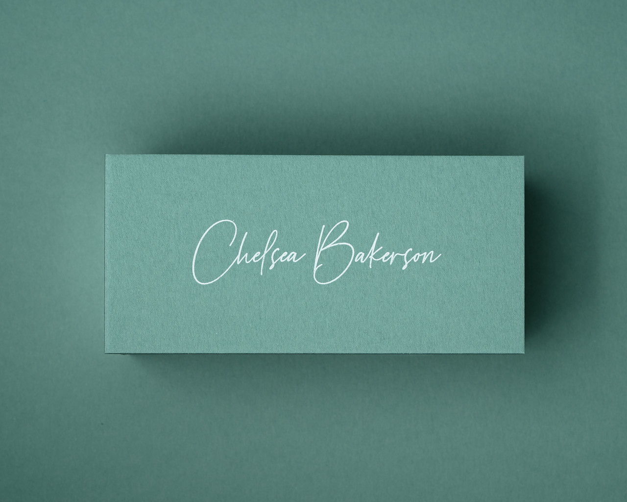 This jade green place card features crisp white ink printing, in a flowing script. The fresh green shade paired with white lettering creates a contemporary, vibrant feel for modern weddings, spring events, or summer dinners.