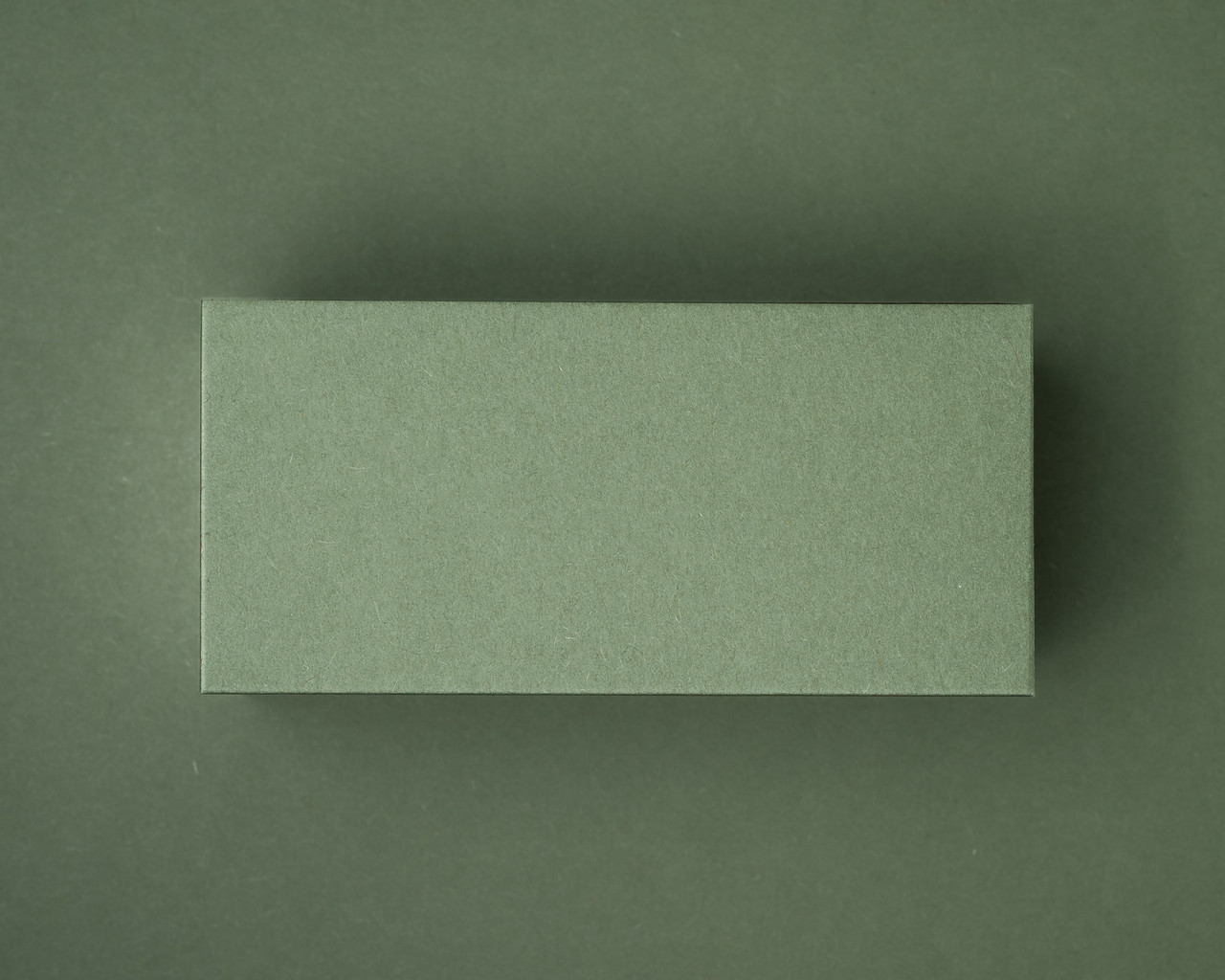 A blank olive green flat place card displayed against a matching olive green background.
