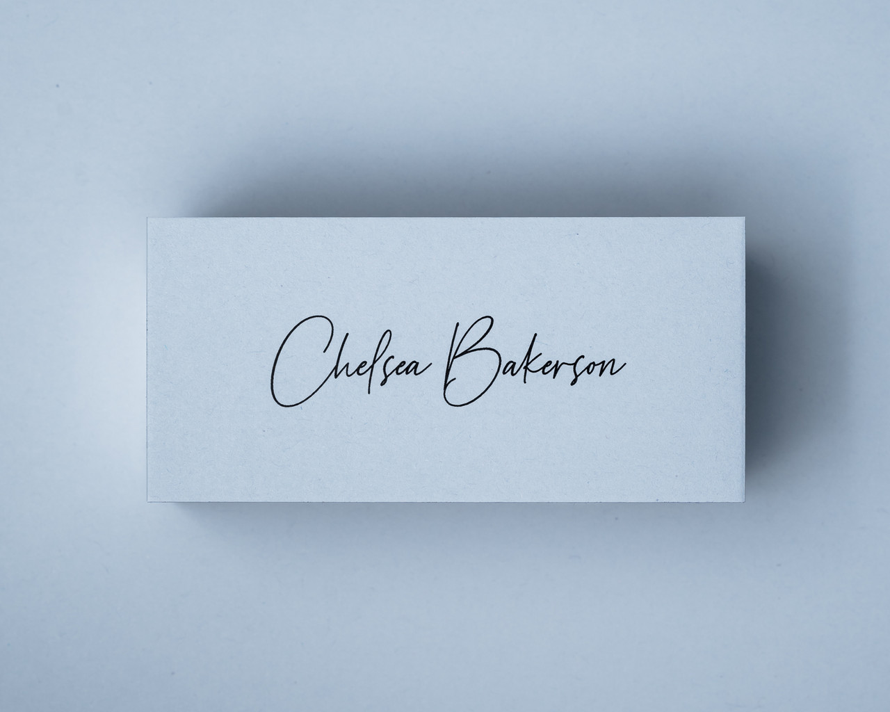 A Powder Blue place card with printed in black ink, showcasing the elegant script font and crisp contrast.