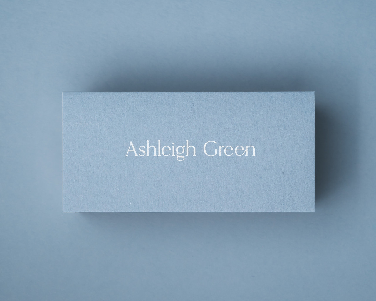 A personalised Dusty Blue place card featuring white ink printing, offering a clean and elegant alternative for light script on coloured stock.