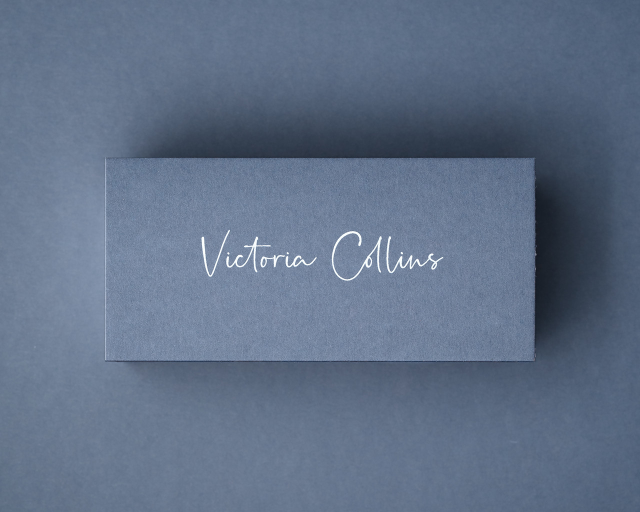 Personalised Airforce Blue place card printed in elegant white ink script, on premium 300gsm card.