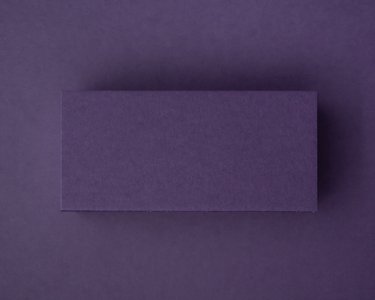 Blank aubergine flat place card made from 300gsm cardstock, displayed against a matching deep purple background.