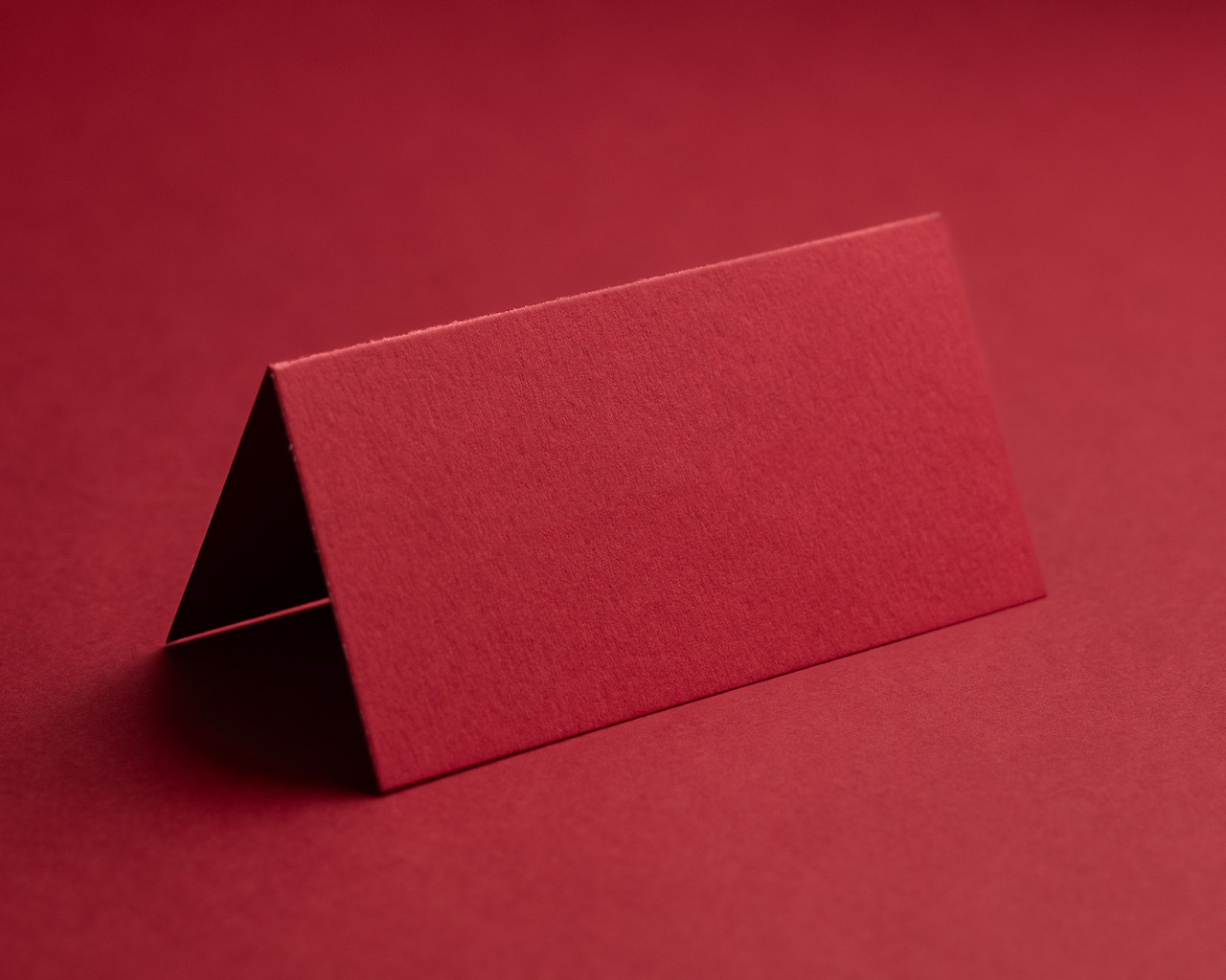 Cherry red folded place card blank on matching background – luxury 300gsm card.