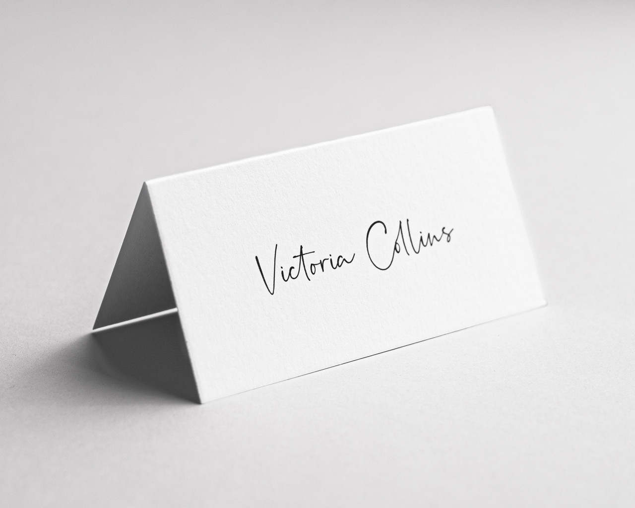 Personalised Pure Cotton folded place card with elegant black ink name printing in script font.