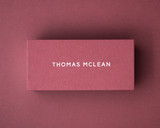 Deep Rose place card printed with sample name "Thomas McLean" in white ink on 300gsm card, illustrating personalised luxury stationery for elegant table settings.