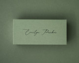 Olive green flat place card with black ink printed name in a modern script font.