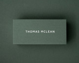 The khaki green flat place card personalised with the name in white ink using a bold, modern typeface.