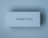 A personalised Dusty Blue place card printed with black ink in a modern calligraphy font.