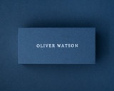A personalised navy blue place card with a name printed in clean white ink, displayed against a matching navy background.