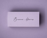 A lilac 300gsm flat place card printed in elegant black ink with a name in a calligraphy script.