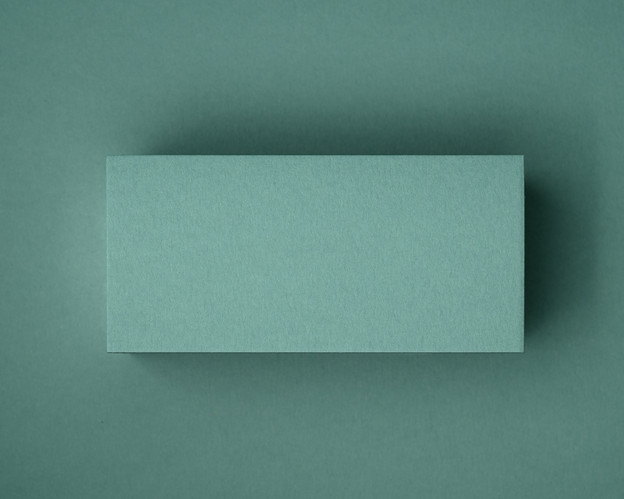 A close-up of a blank jade green flat place card, photographed on matching coloured paper. This image showcases the smooth matte finish and natural texture of the 300gsm cardstock — perfect for elegant table styling at weddings, events or private dinners.