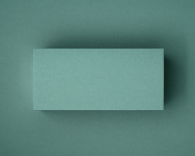 A close-up of a blank jade green flat place card, photographed on matching coloured paper. This image showcases the smooth matte finish and natural texture of the 300gsm cardstock — perfect for elegant table styling at weddings, events or private dinners.