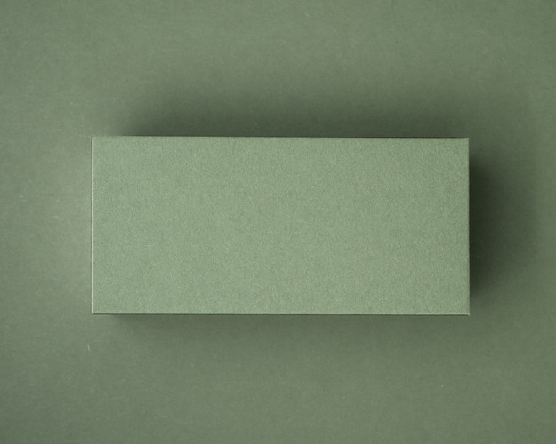 A blank olive green flat place card displayed against a matching olive green background.