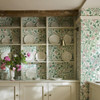 Kitchen interior styled with Little Greene May’s Tulip Linen Wash wallpaper, showing the flowing floral pattern across shelving and cabinetry.