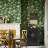 Rose Garden wallpaper in Puck by Little Greene used in a dining room, creating a rich green floral backdrop with classic furniture.