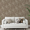 Grandeco Prairie Chocolate wallpaper styled behind a neutral sofa, highlighting the flowing botanical pattern against the warm brown backdrop.