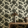 Harlequin Zamora Onyx wallpaper styled behind a wooden console table, showcasing dramatic black floral design.