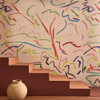 Harlequin Pintura Majorelle Spice Forest wallpaper styled along a staircase wall, emphasising bold multicoloured brushstroke design.