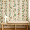 Scion On The Vine Tangerine Kelly Green wallpaper styled behind a wooden bench showing colourful fruit trail pattern.
