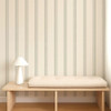 Scion Fondant Stripe Mushroom wallpaper styled behind a wooden bench, showcasing neutral striped design.