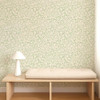 Scion Flo Swirl Pine wallpaper styled behind a wooden bench, showcasing green swirling line design.