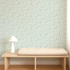Scion Dove & Deer Coast Blue wallpaper styled behind a wooden bench, showcasing detailed woodland motif.