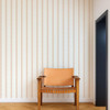 Scion Harvest Stripe Tangerine wallpaper used in a neutral interior, highlighting warm striped pattern.