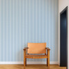 Scion Harvest Stripe Cornflower wallpaper in a neutral interior, showing calming blue vertical stripes.