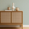Scion Ditsy Daisy Powder Blue wallpaper used behind a rattan-front cabinet, highlighting soft blue floral design.