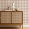 Scion Central Check Blush wallpaper used behind a rattan-front cabinet, highlighting warm blush gingham design.